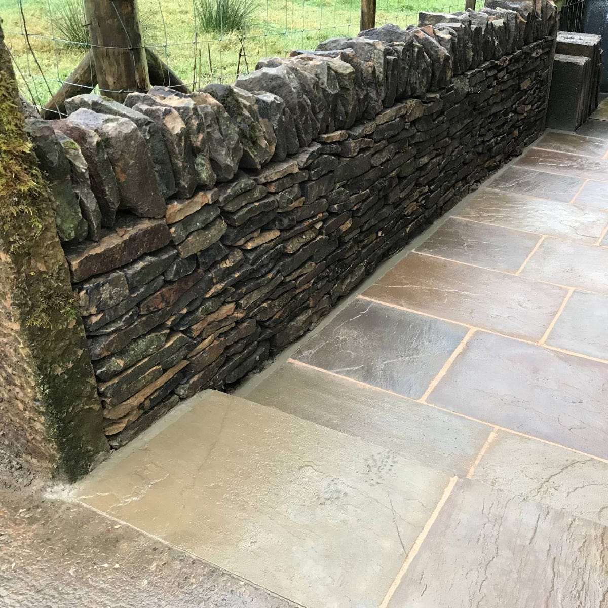 A curved dry stone boundary garden wall