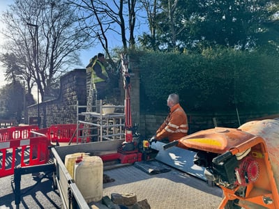 Professional vehicle damage repair work on stone wall - insurance claim restoration